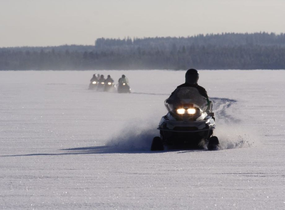 Snowmobiles crossing a lake.