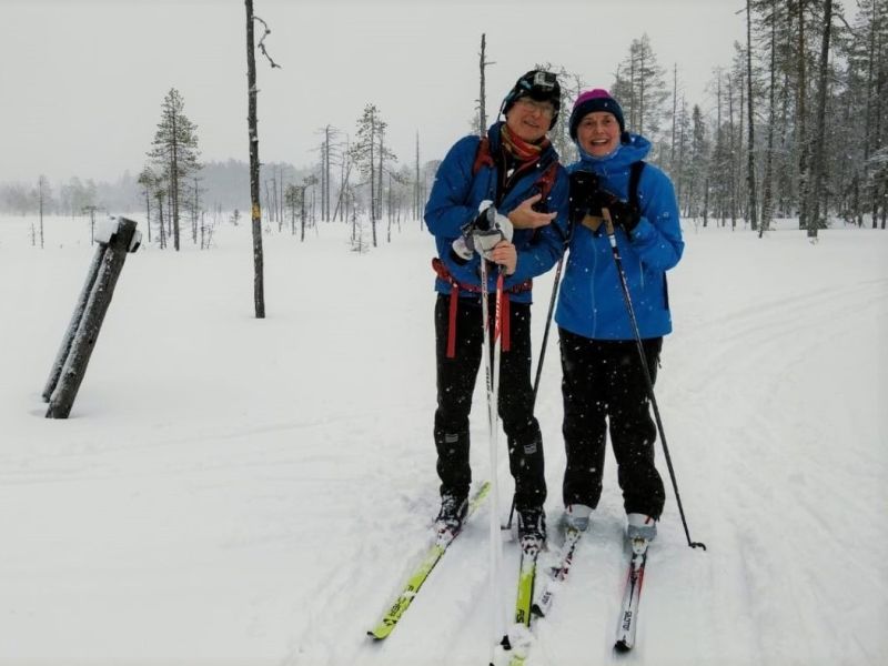 A couple on skis on a forest track.