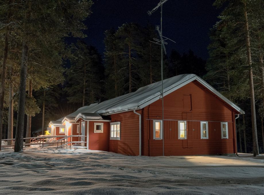 A large red wooden cabin at night