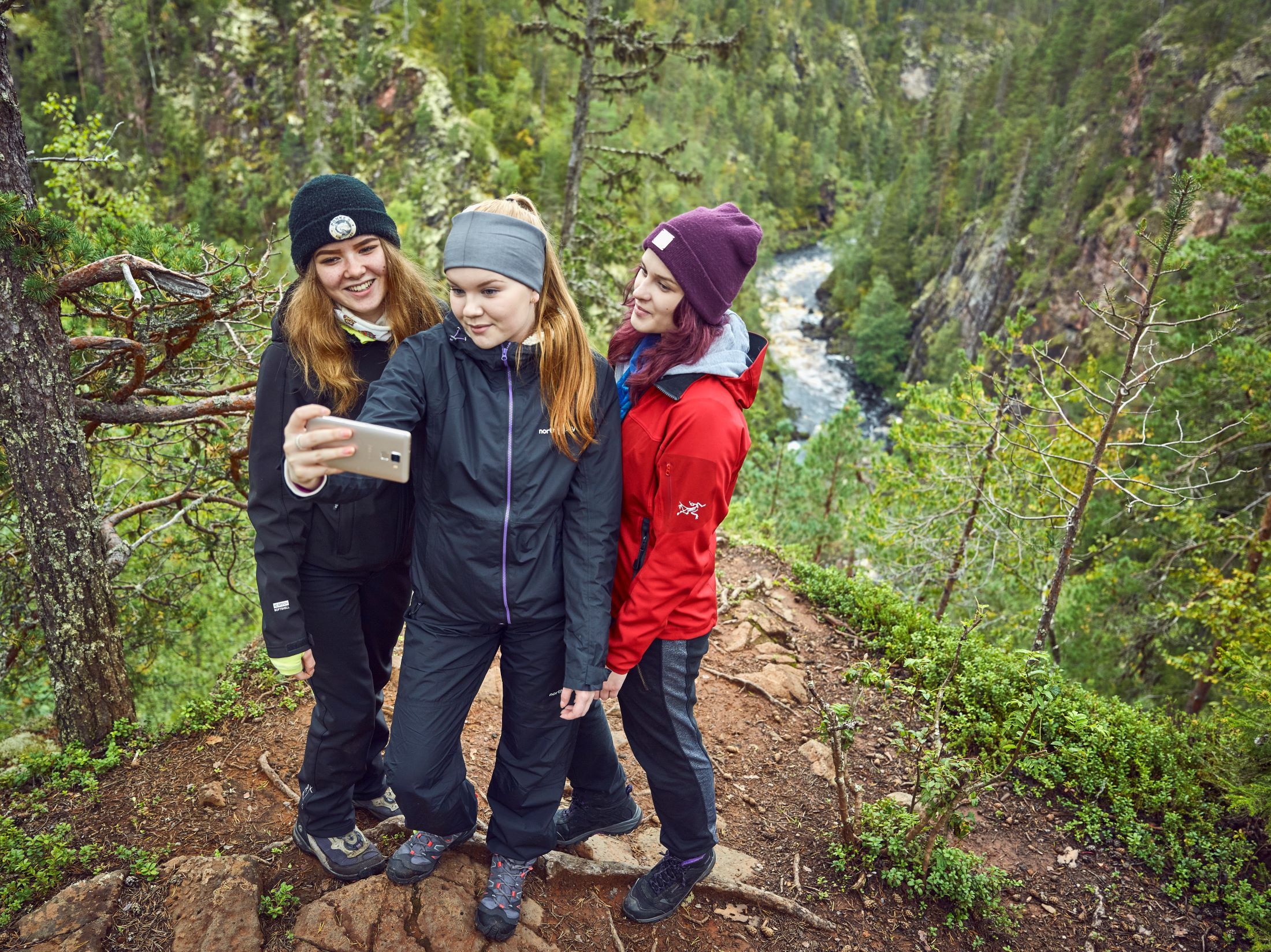 Three girls taking a selfie on a cliff. 