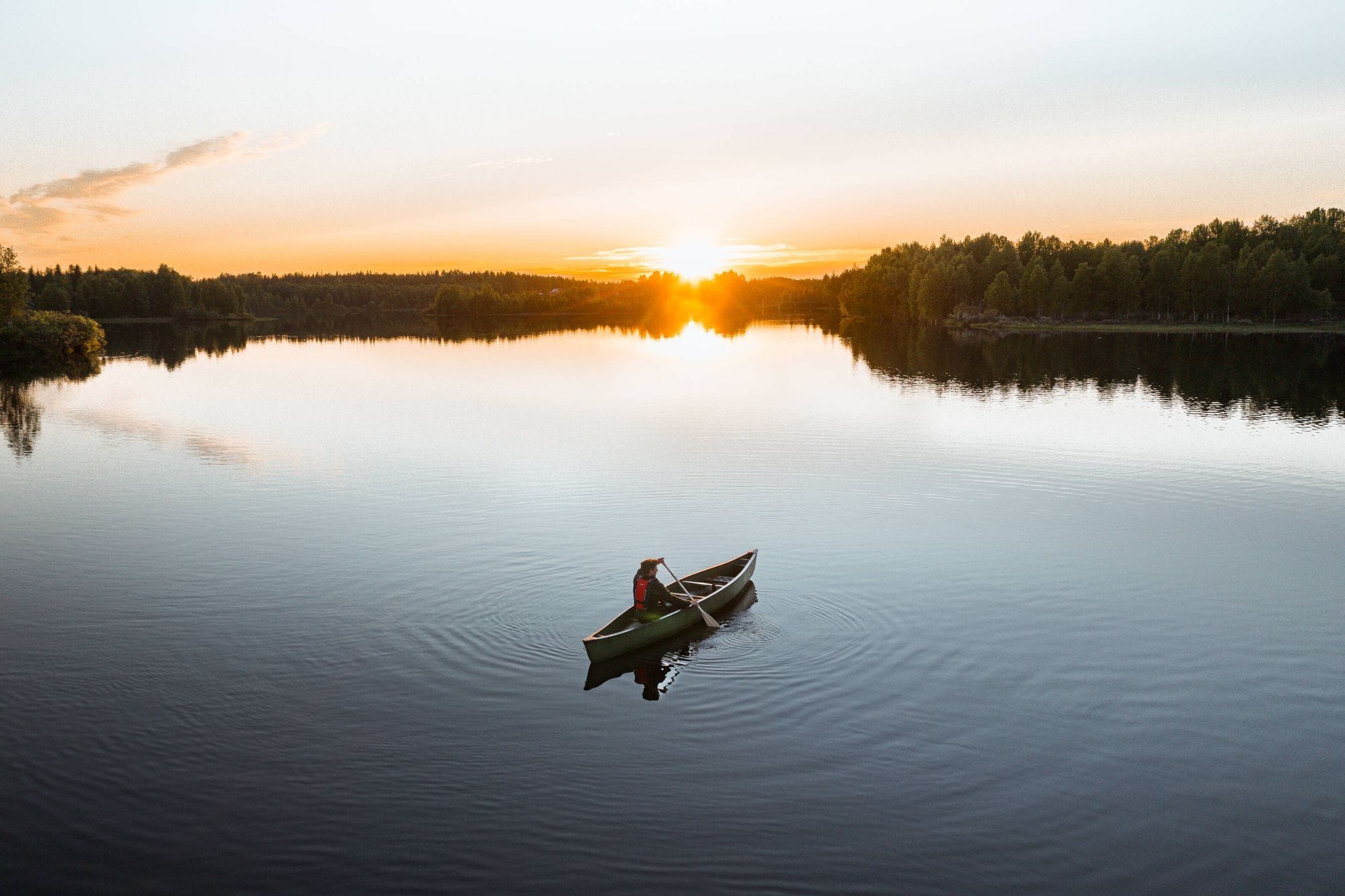 A canoe on a calm lake at sunset