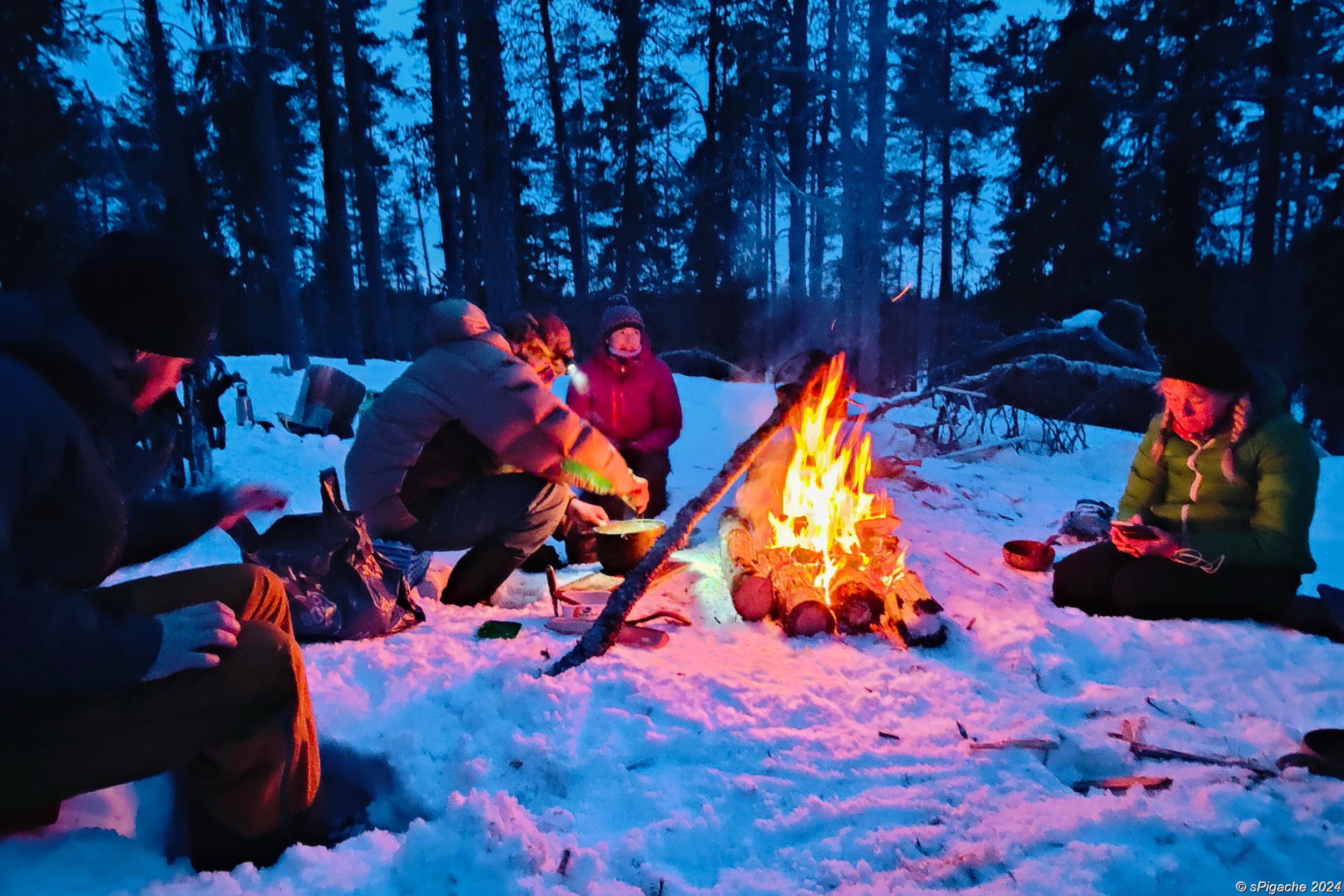 People around an open fire in the dusk