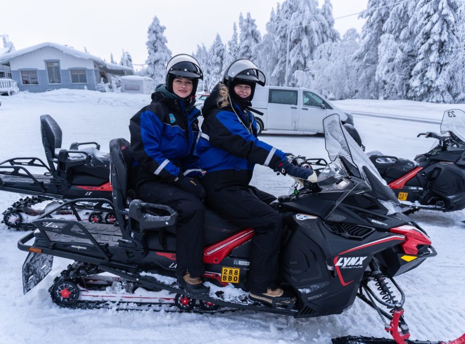 Two girls ready to go on a snowmobile